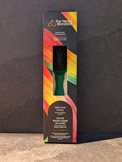 Retail packaging box for The Neuro Standard's sensory-friendly hairbrush, featuring a black box with a vibrant rainbow design.