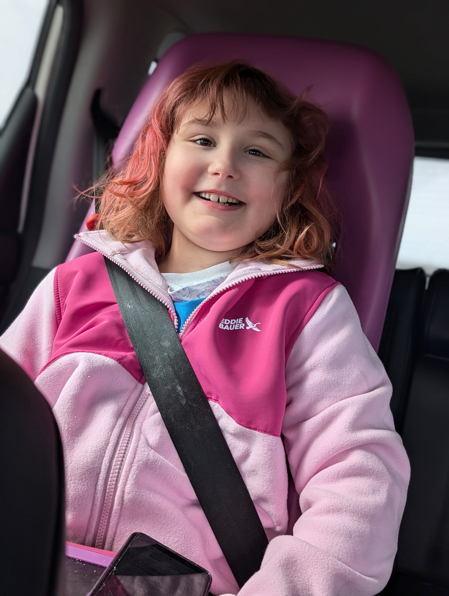 A smiling Maya sitting in her car seat wearing a pink jacket, with her pinkish-blonde hair looking smooth and well-managed. The final section of 'Our Story' by founder Janice Ayotte explains that The Neuro Standard was built for people who were never considered in original designs.