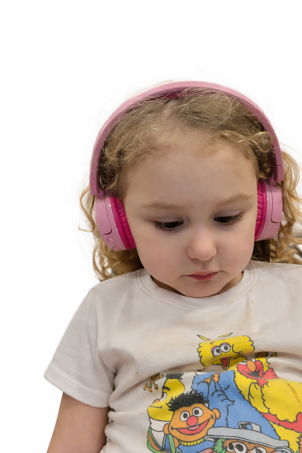 Young girl with blonde curls wearing pink noise-canceling headphones, looking down thoughtfully. To her left, the 'Our Story' text for The Neuro Standard discusses the challenges neurodivergent people face in a world not designed for them.